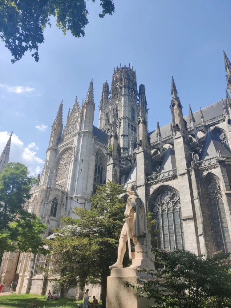 Vue d'une grande église gothique avec une sculpture de dos au premier plan