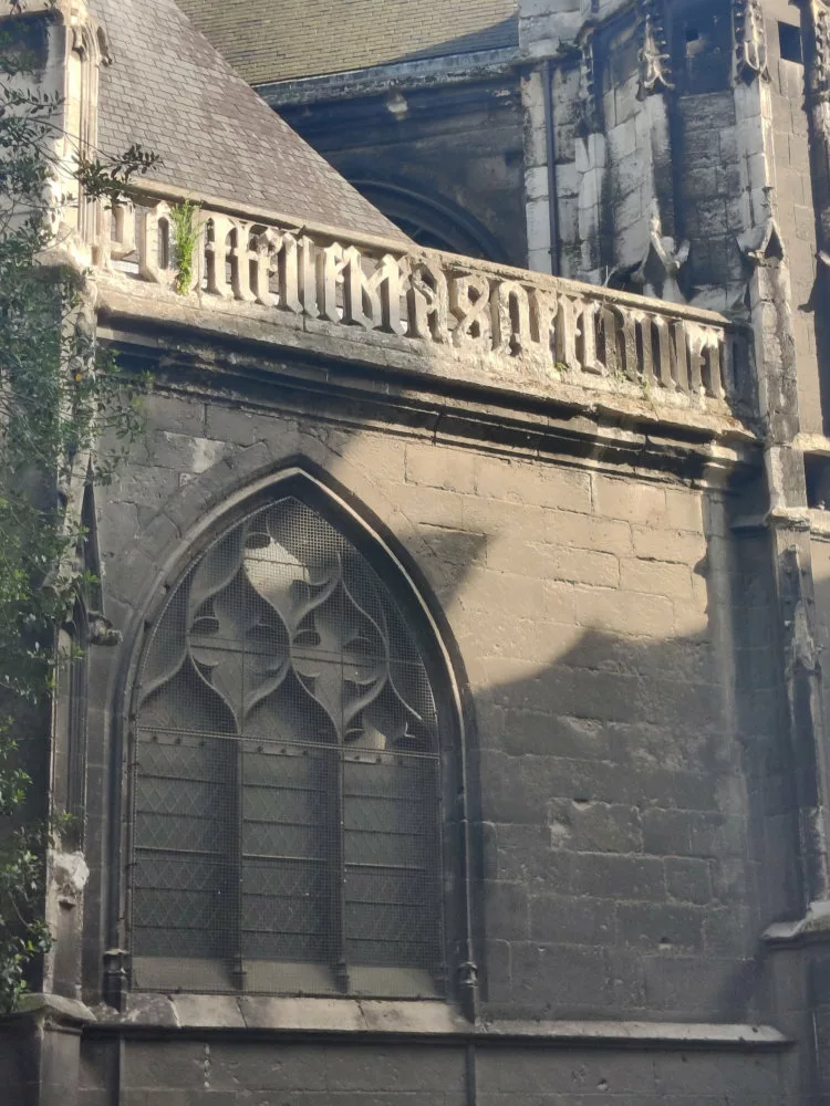 Détail d'une église dont une balustrade est faite en écriture gothique