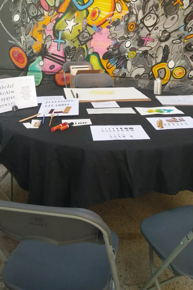 Une table avec du matériel de calligraphie et des chaises