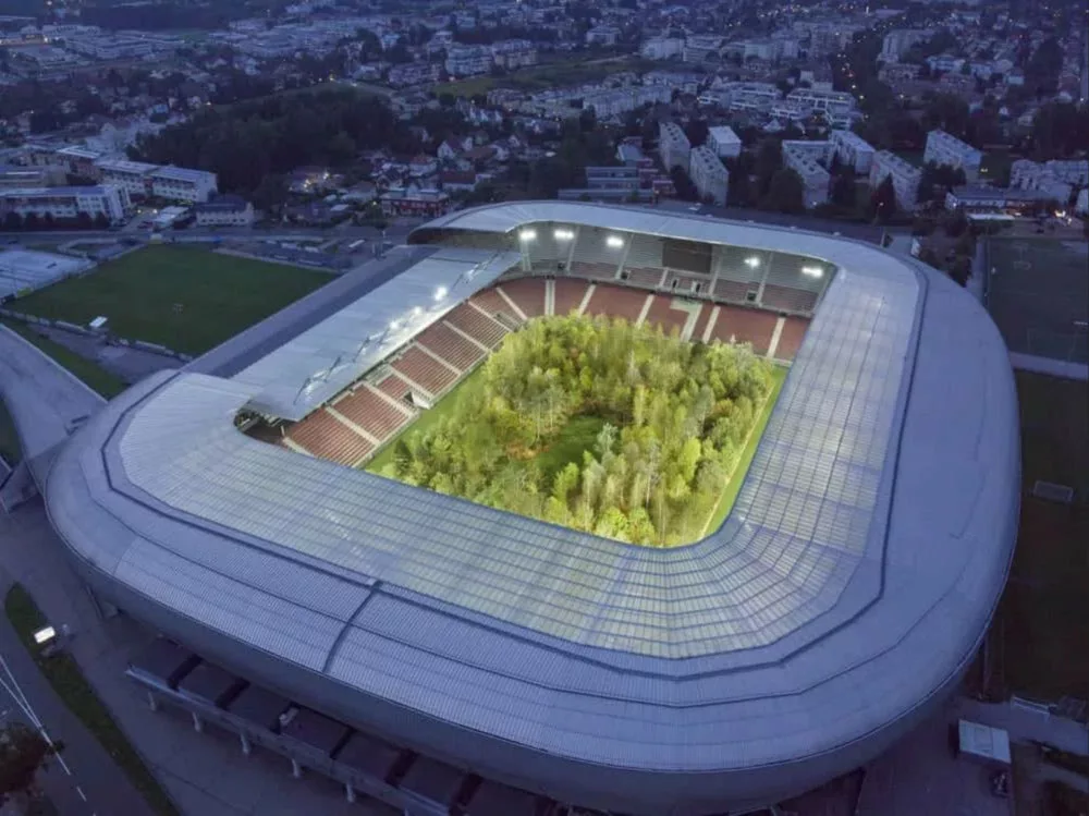 Un stade en vue aérienne dont le terrain est planté d'arbres