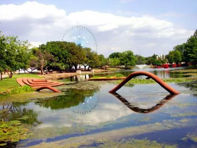 Une structure de forme organique sort et rentre d'un plan d'eau dans un parc